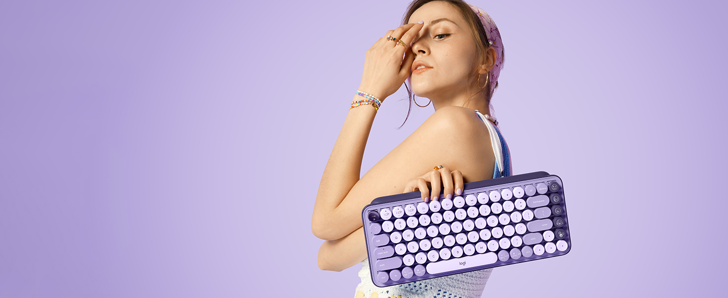 woman posing with pop keys cosmos wireless mechanical purple keyboard in her hand